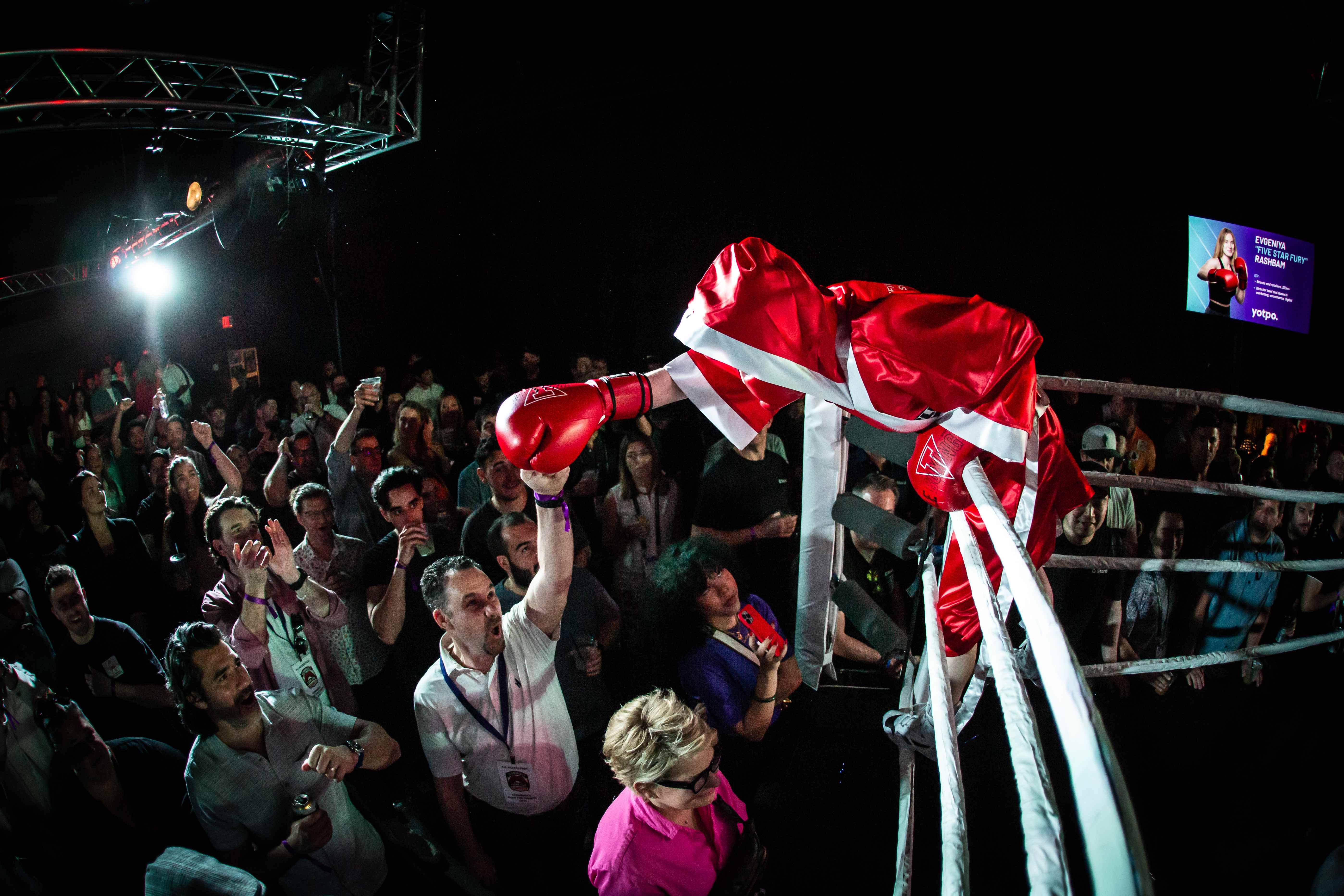 Excited crowd cheering for boxer at the ring