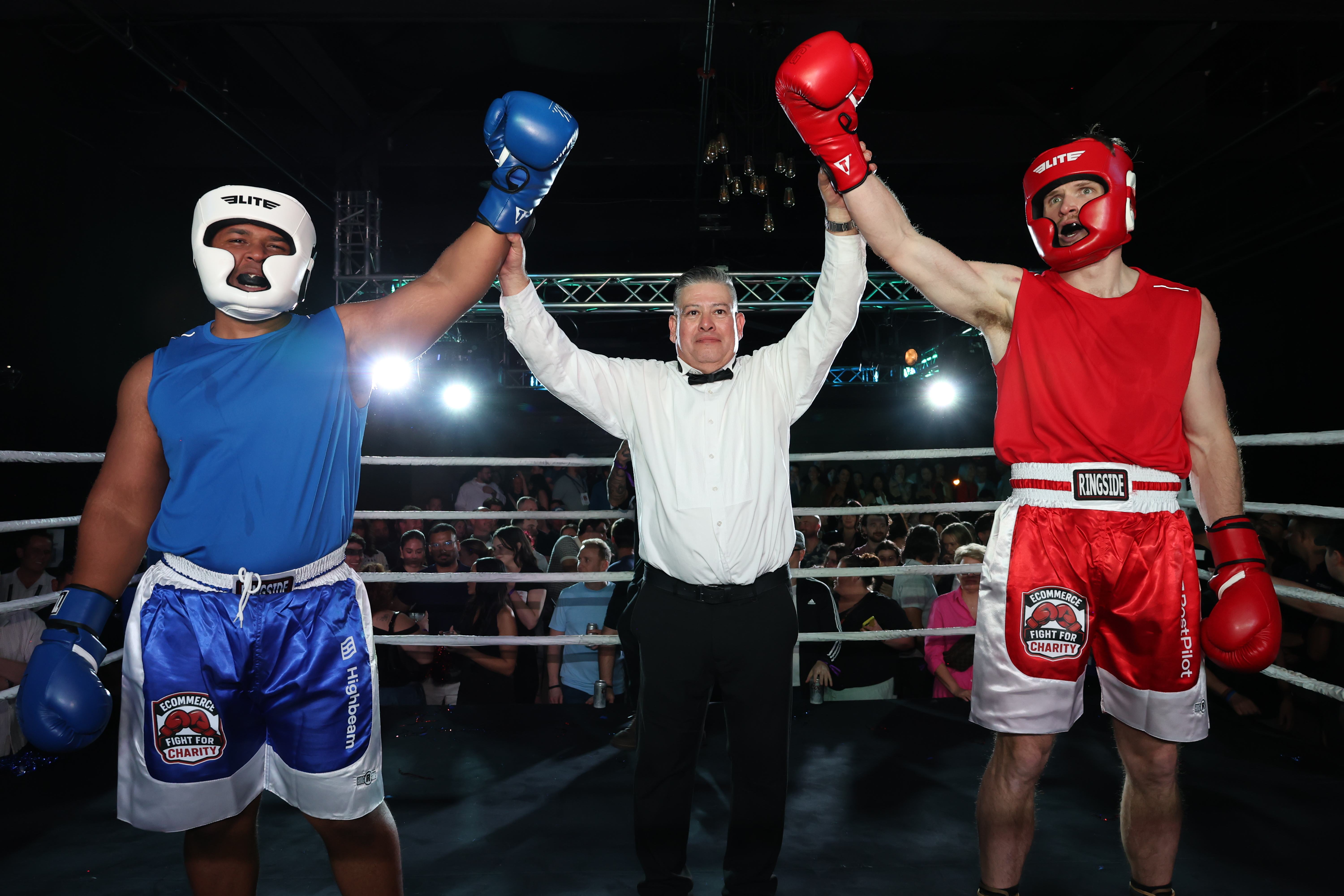 Referee raising both boxers hands in victory
